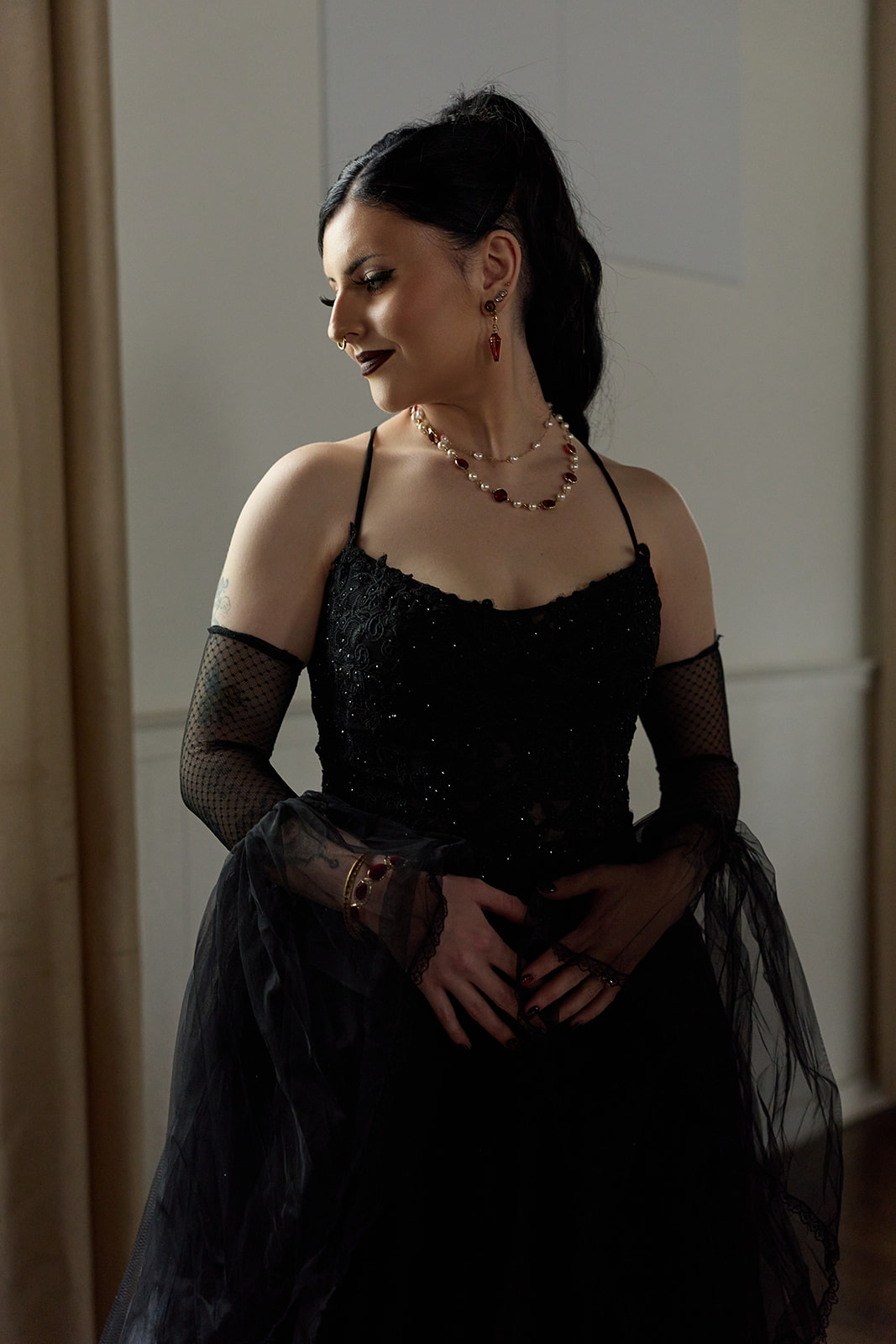 Bride in black lace gloves and a black gown in soft window light