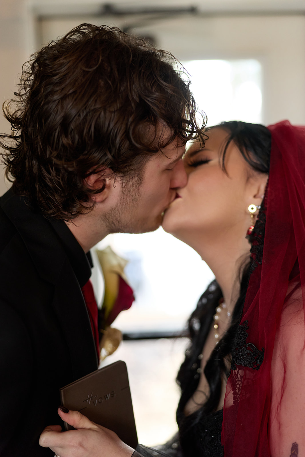 Bride and groom kissing after reading private vows before their wedding ceremony