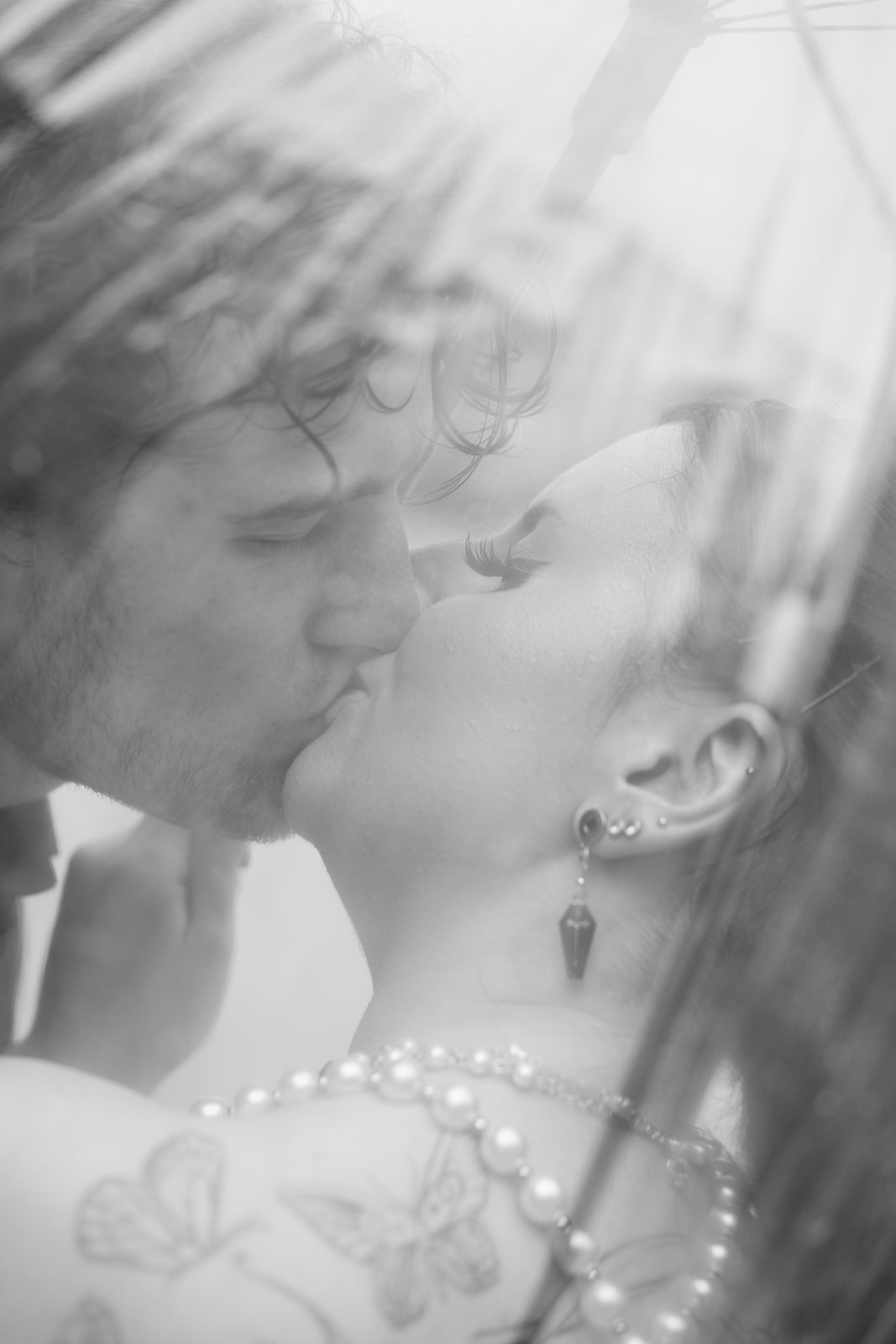 Soft black and white close-up of the bride and groom kissing