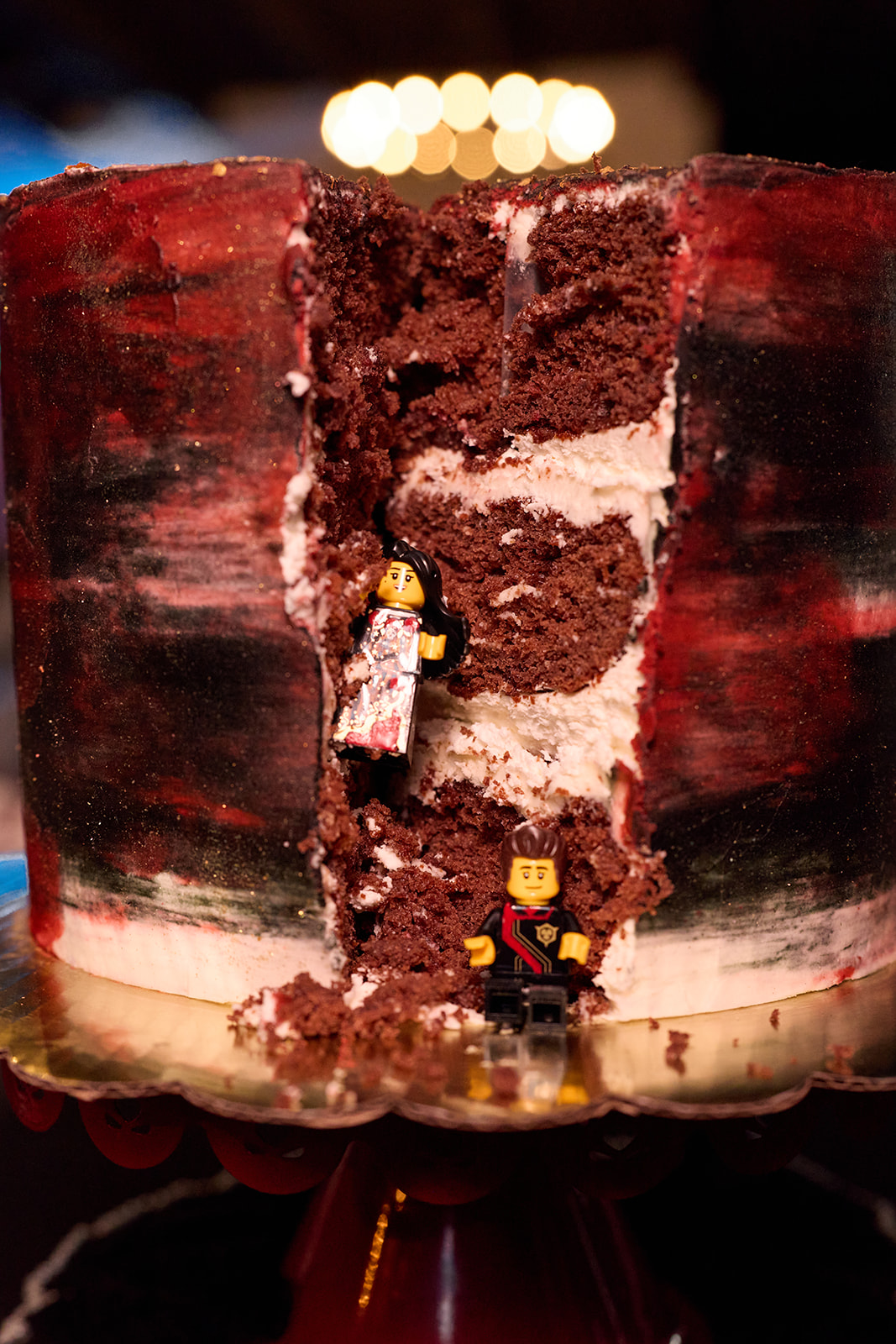 Slice of red and black wedding cake with Lego minifigures inside